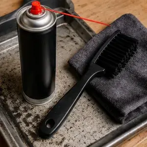 limpiar-engrasar-cadena-moto-Spray, cepillo y paño preparados para el mantenimiento de una cadena de moto